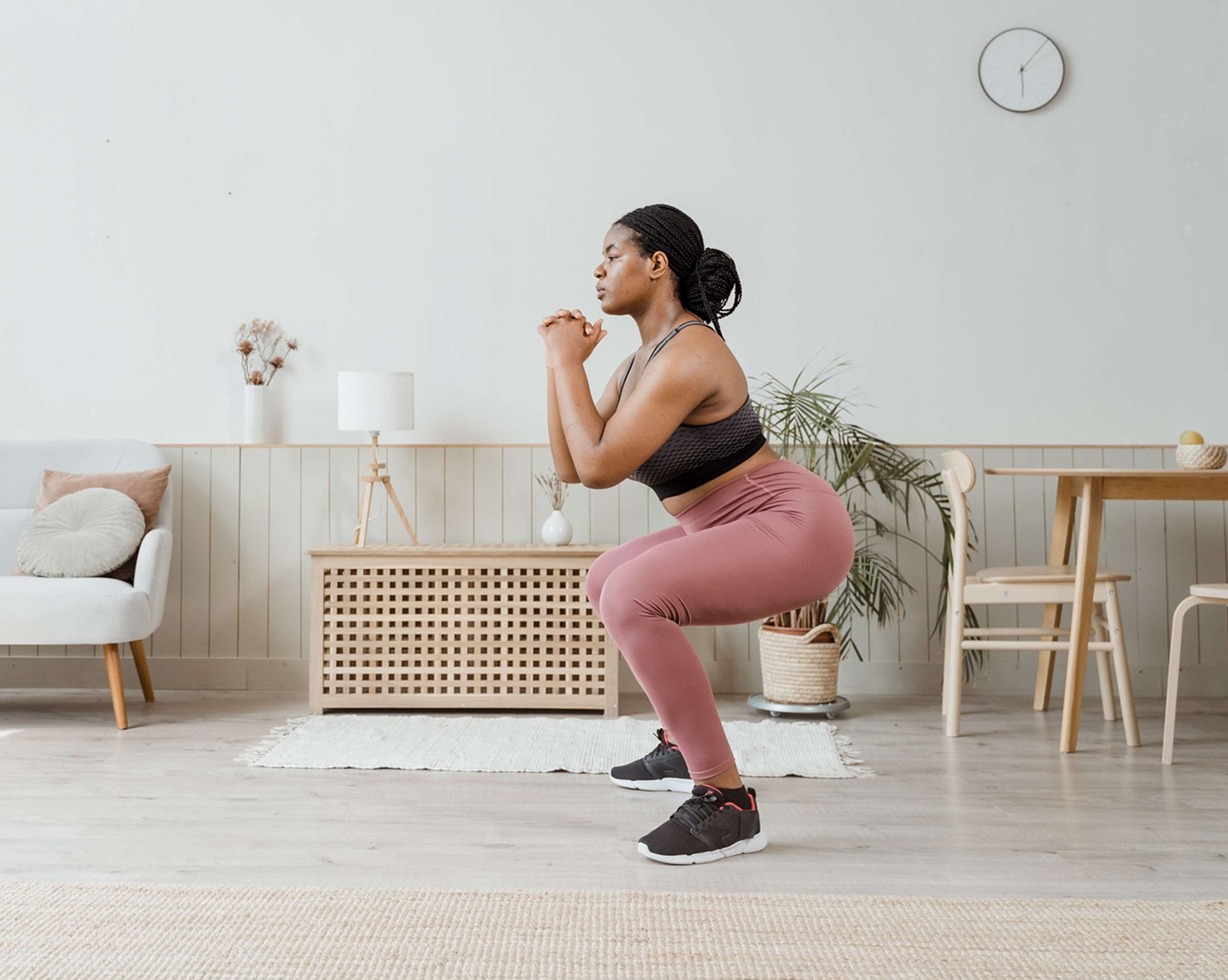 Person performing a squat in a bright living room